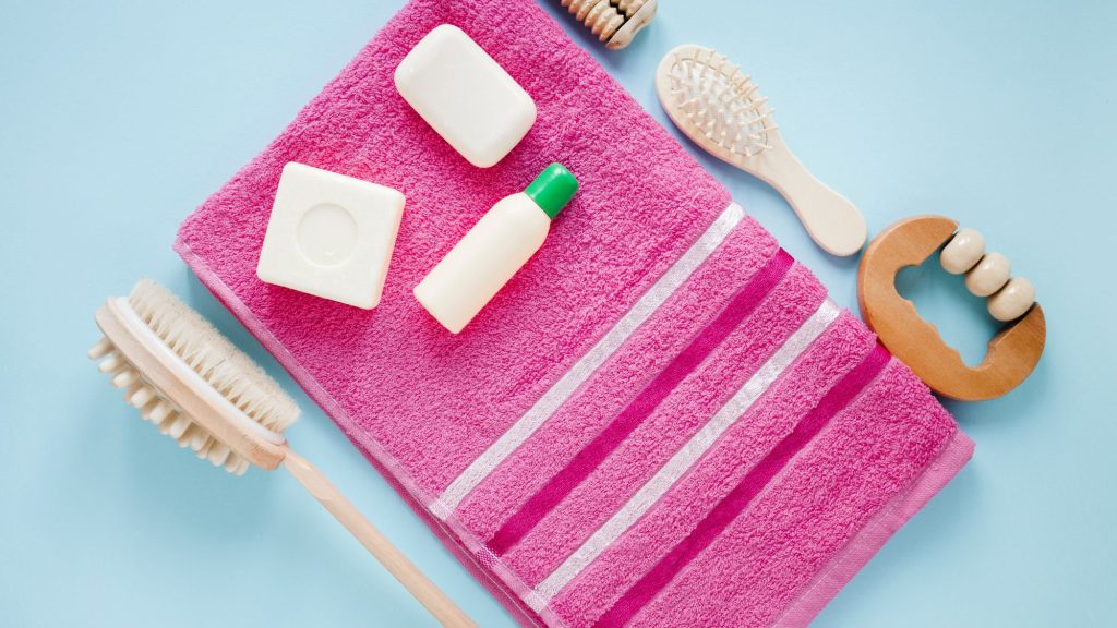A assortment of essential bathroom accessories and a pink towel